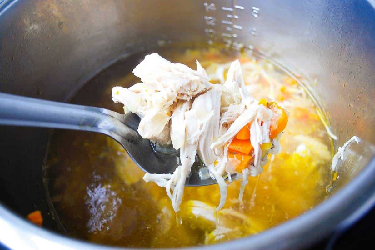 a large spoonful of shredded chicken over an instant pot
