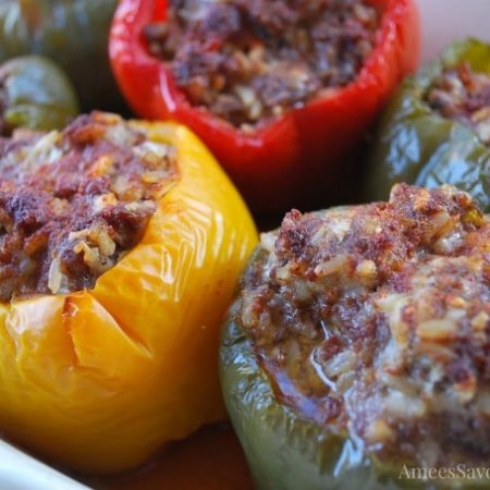Baked stuffed red, yellow, and green peppers in a baking dish