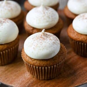close up of a frosted pumpkin cupcake on a platter