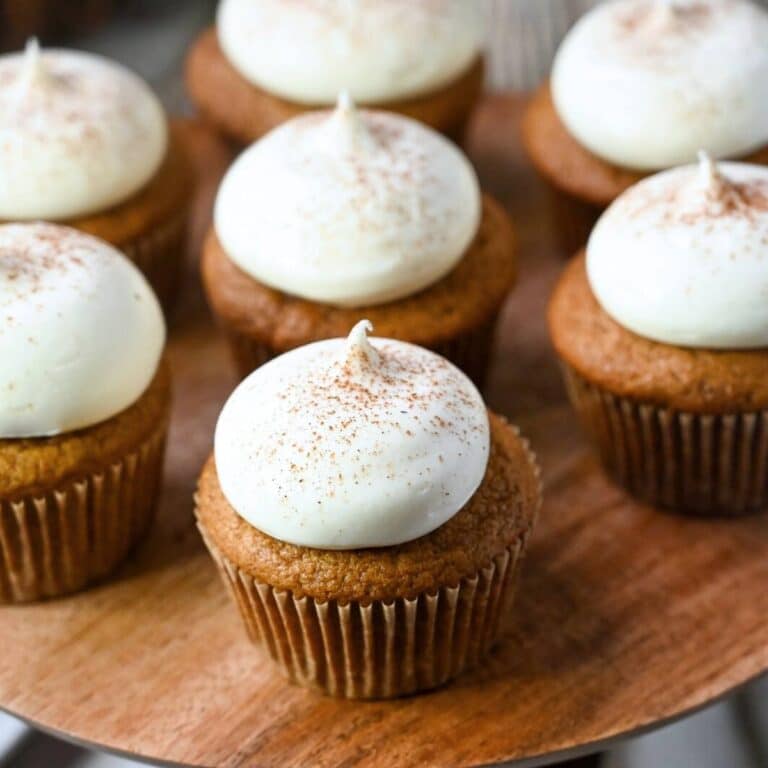 a platter of maple cream cheese frosted pumpkin pie spice cupcakes with cinnamon sprinkled on top