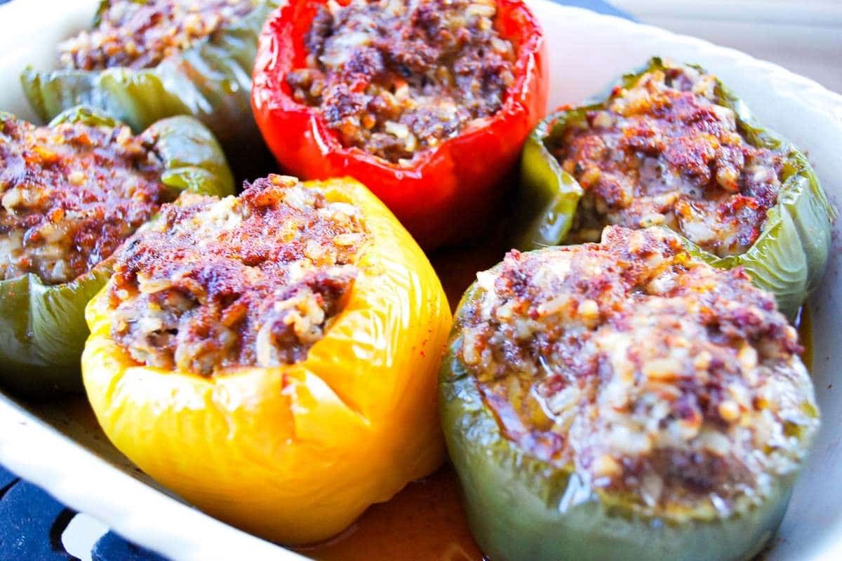 Six stuffed peppers in a baking dish 
