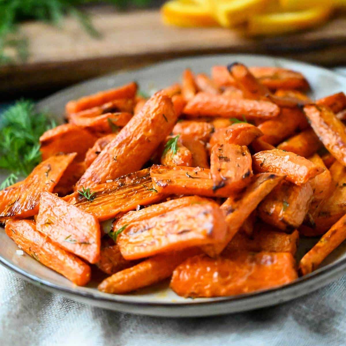 a plate of roasted carrots garnished with fresh dill