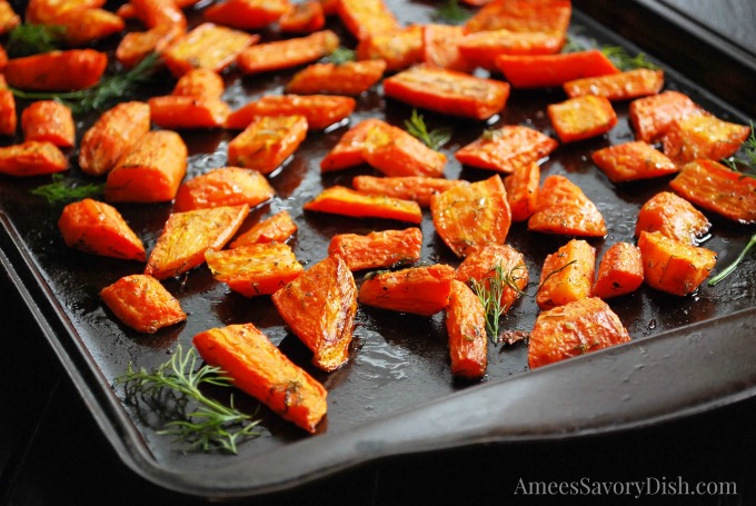 Roasted carrots on a baking sheet with fresh dill