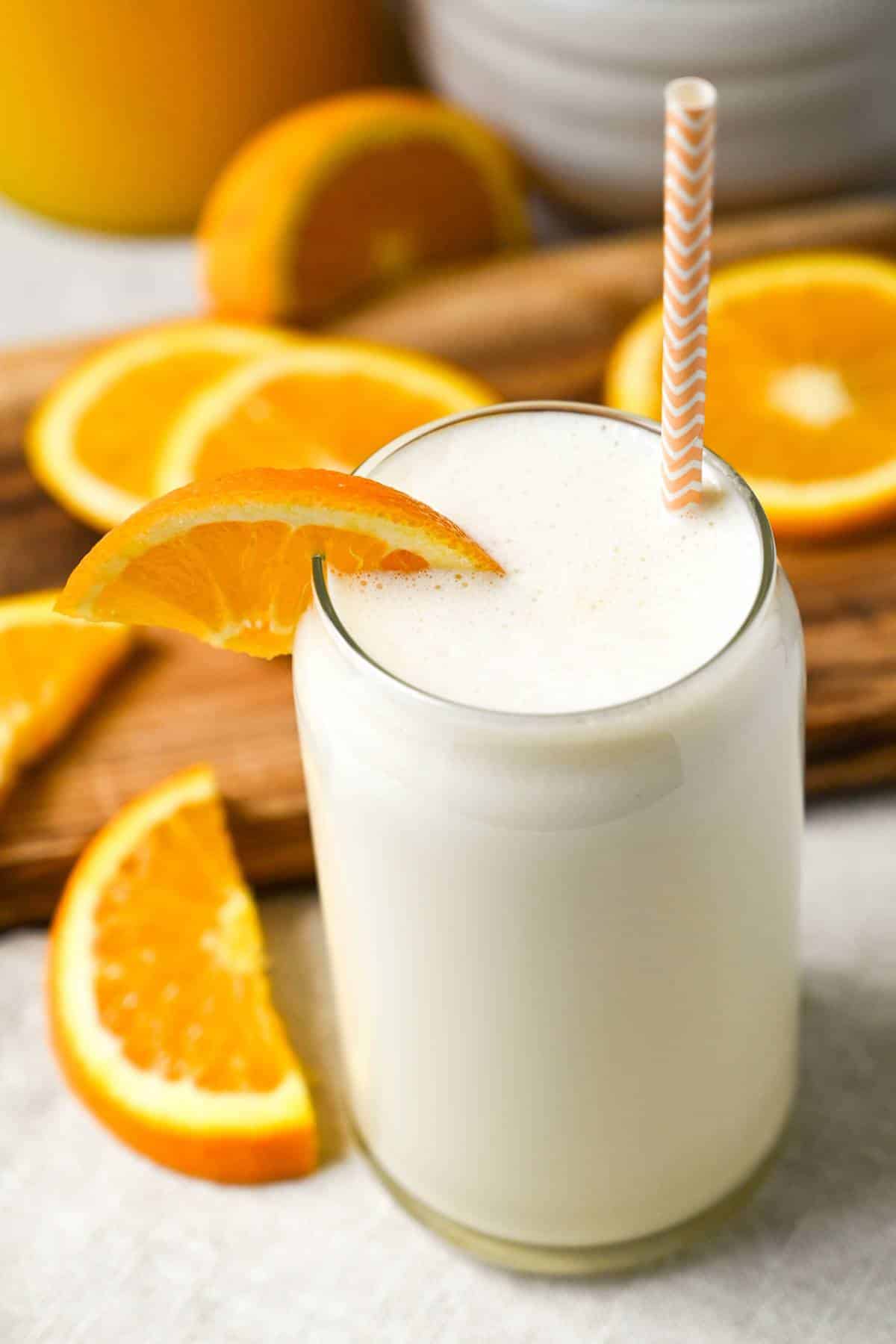 freshly blended orange vanilla yogurt protein shake with an orange slice on the glass