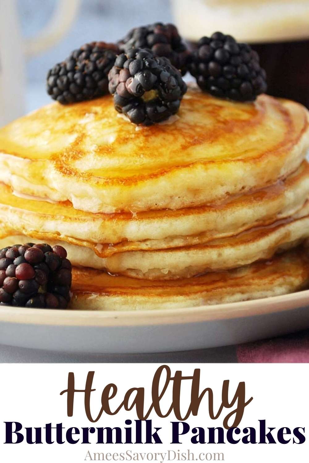 close up of a stack of buttermilk pancakes topped with fresh blackberries and syrup