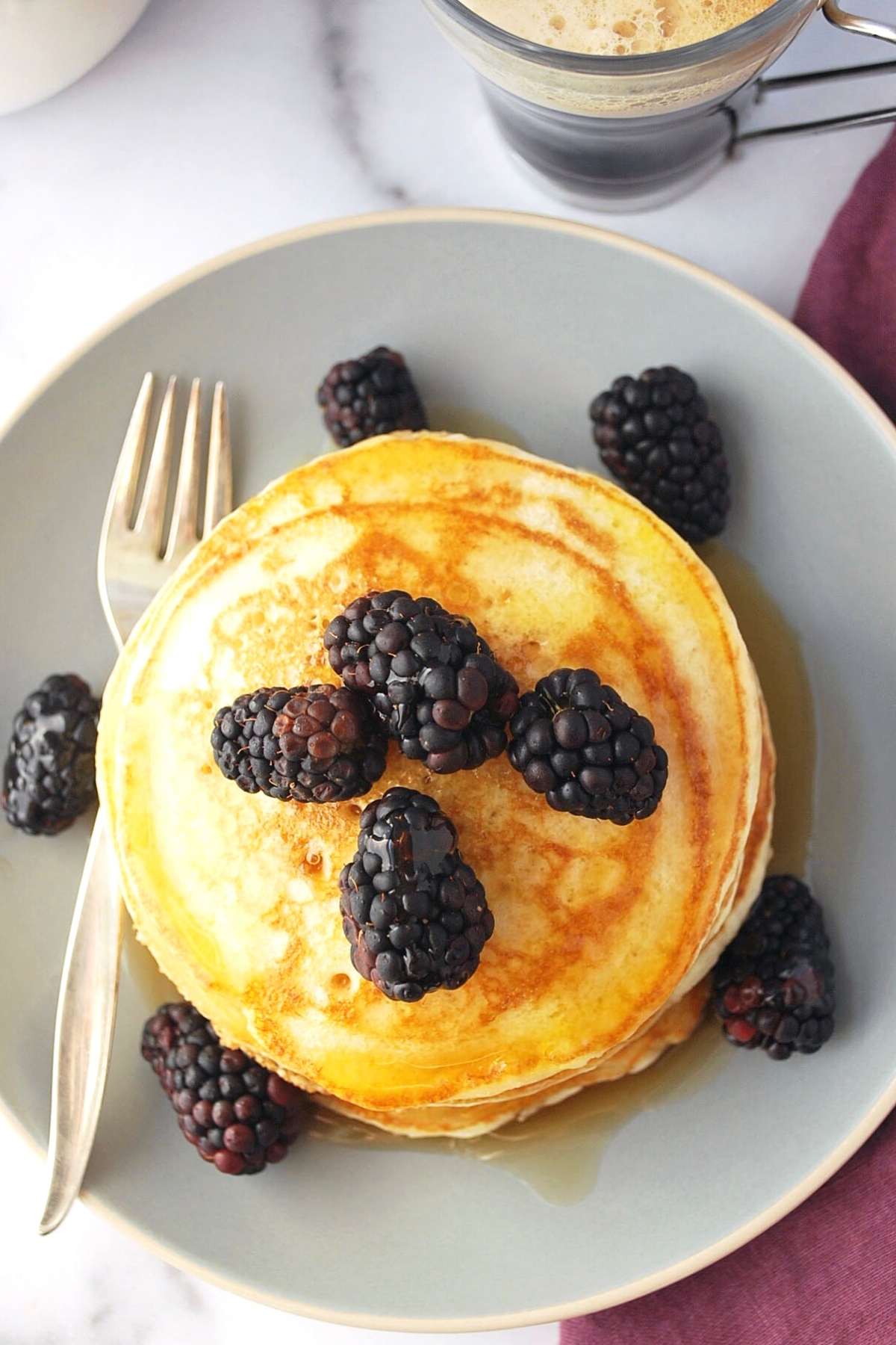 overhead photo of a plate of pancakes topped with blackberries