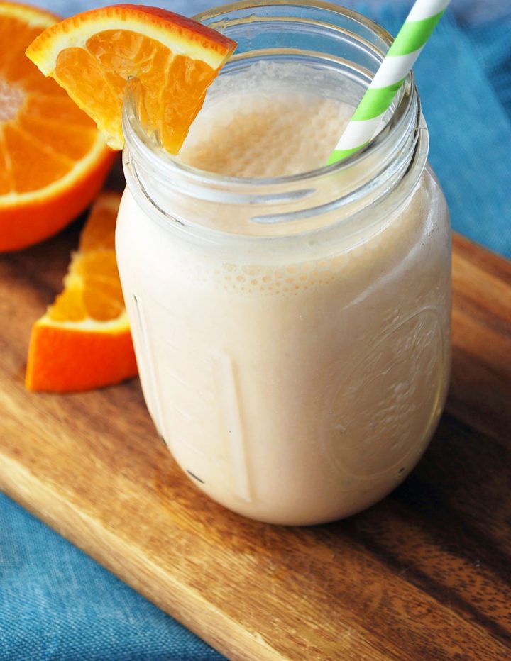 orange creamsicle shake with green straw and orange wedge