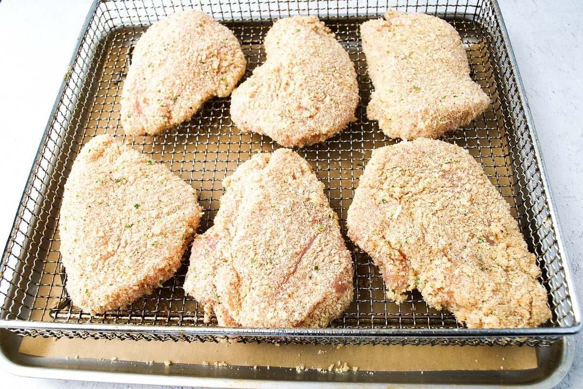 breaded chicken breasts in an air fryer basket