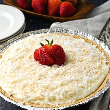coconut cream pie topped with a sliced strawberry