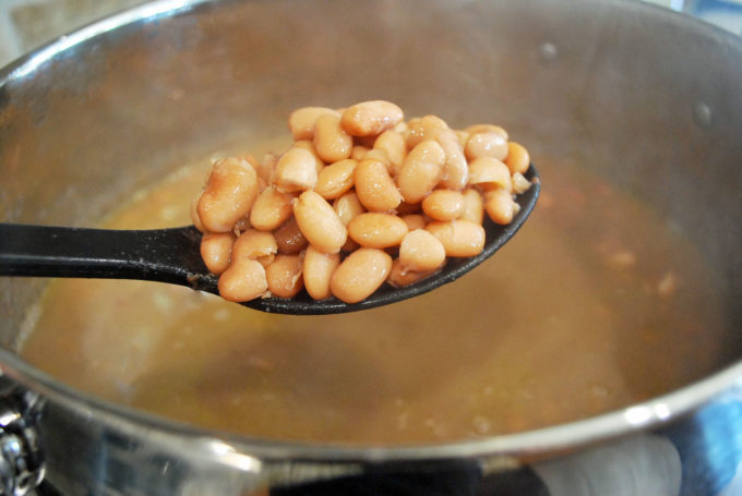 cooked pinto beans on a spoon