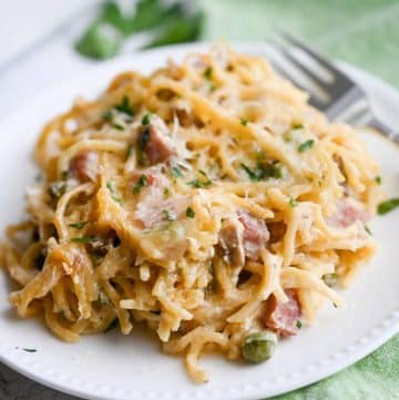 ham casserole with peas and parmesan cheese on a plate with a fork
