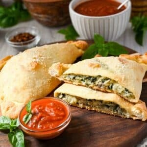 a sliced spinach and cheese calzone with sauce