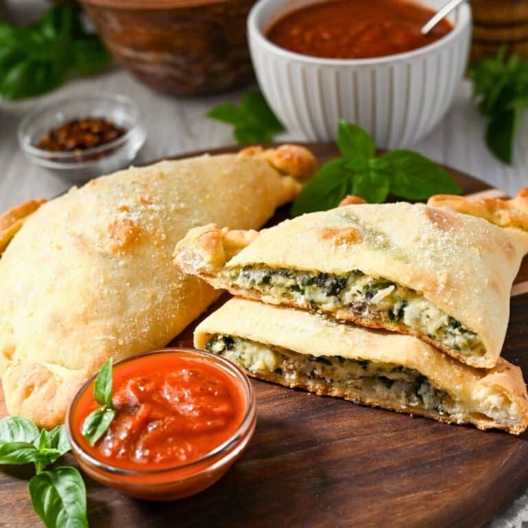 a sliced spinach and cheese calzone with sauce