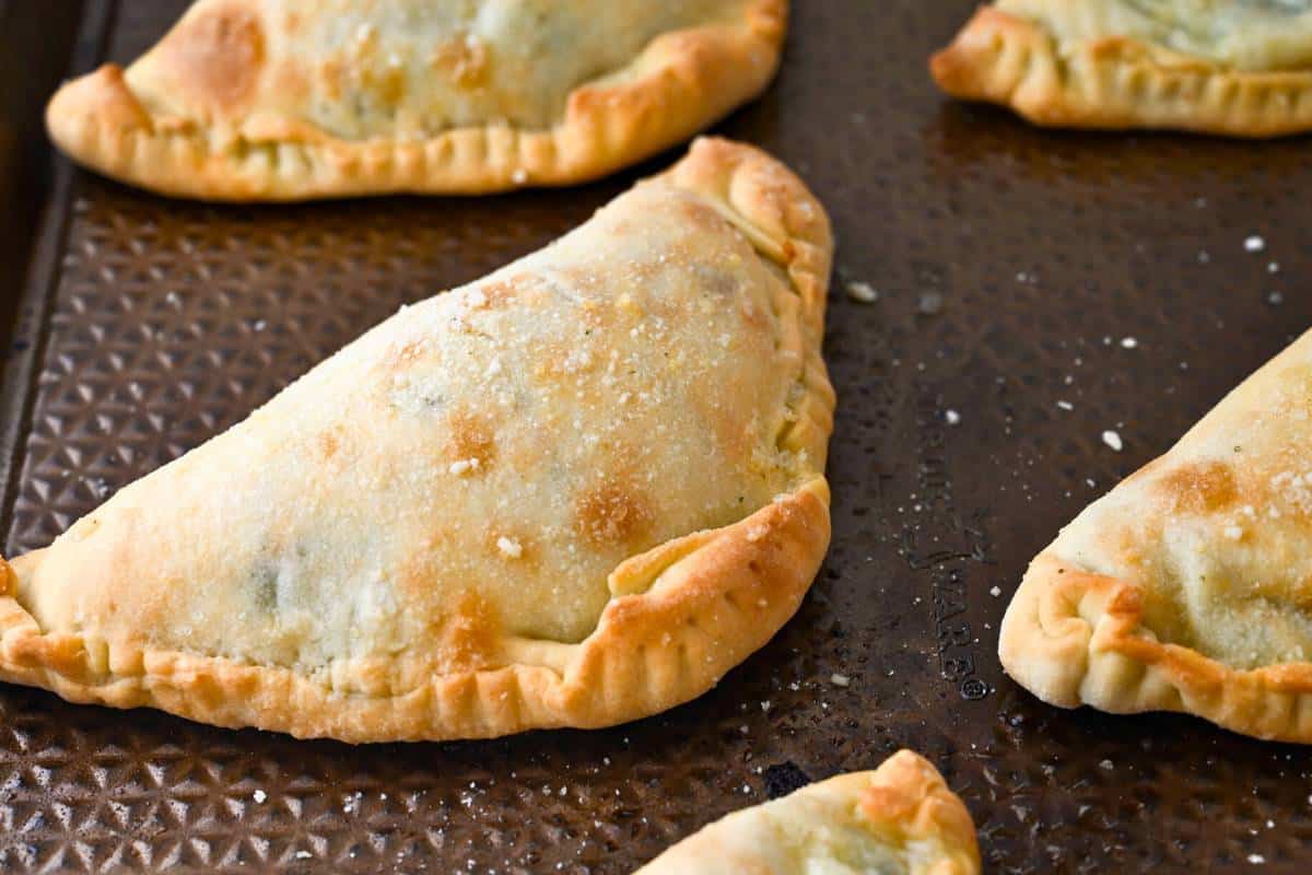 baked calzones on a baking sheet