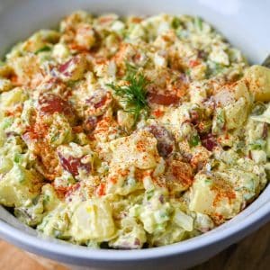 overhead photo of a bowl of red skin potato salad with paprika sprinkled on top