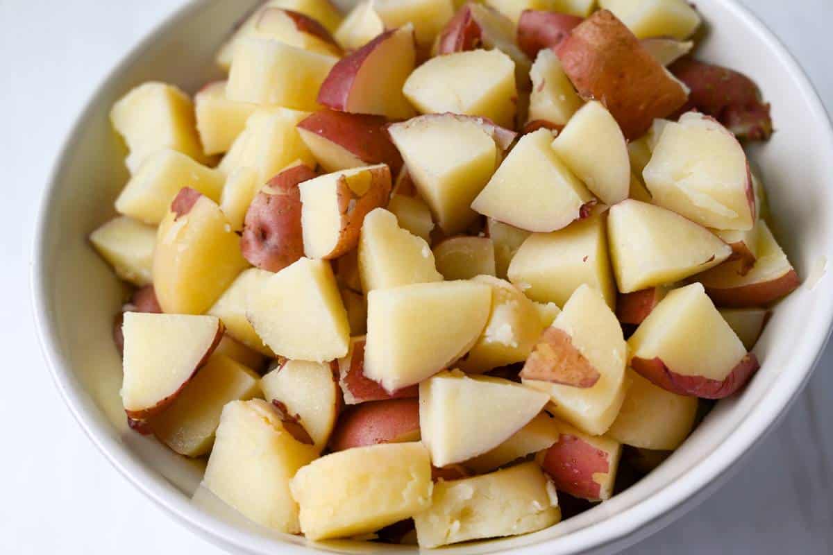 chopped cooked red skin potatoes in a white bowl