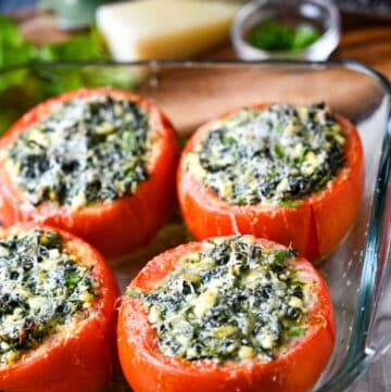 stuffed tomatoes in a baking dish topped with parmesan cheese