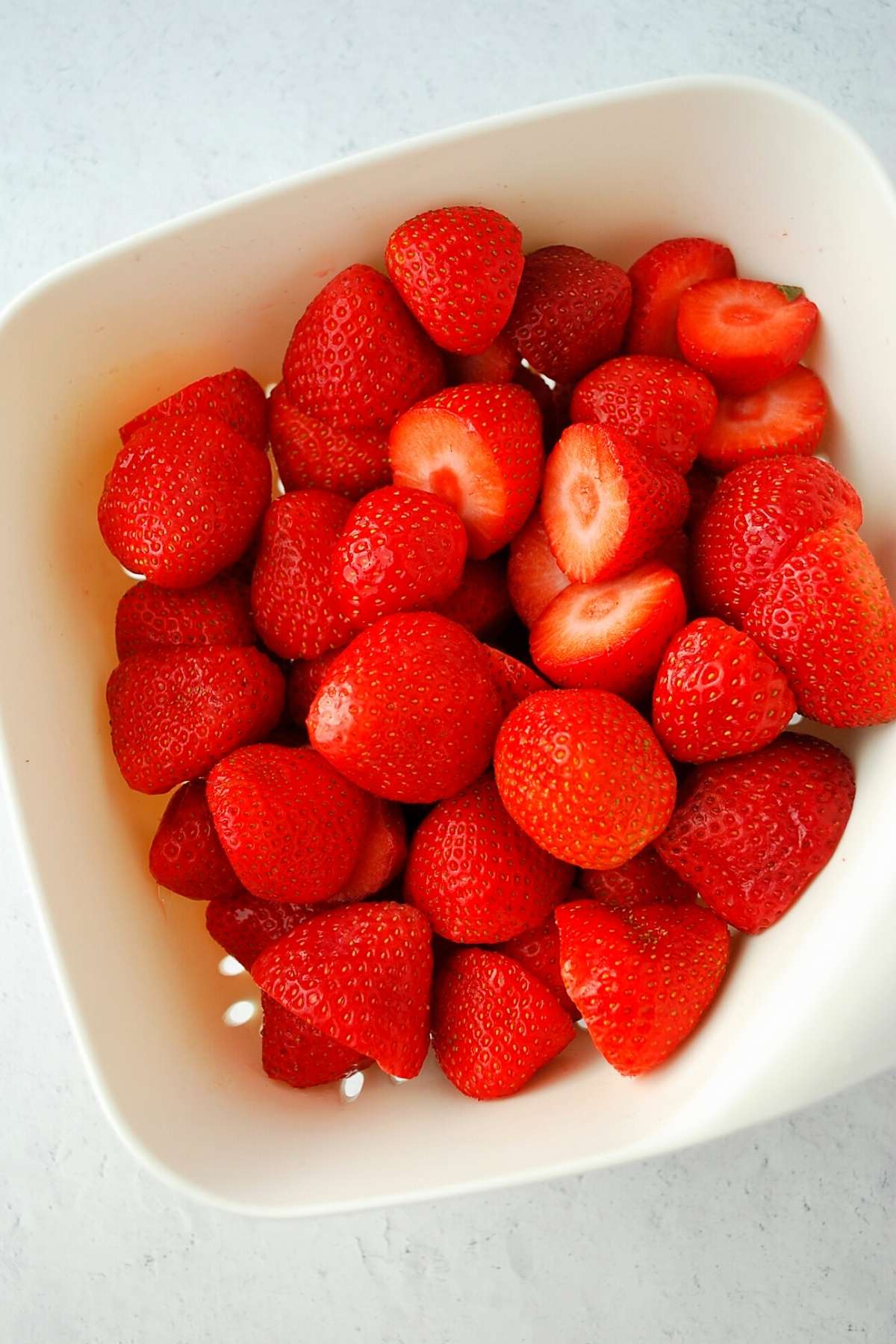 bowl of fresh strawberries with stems cut off