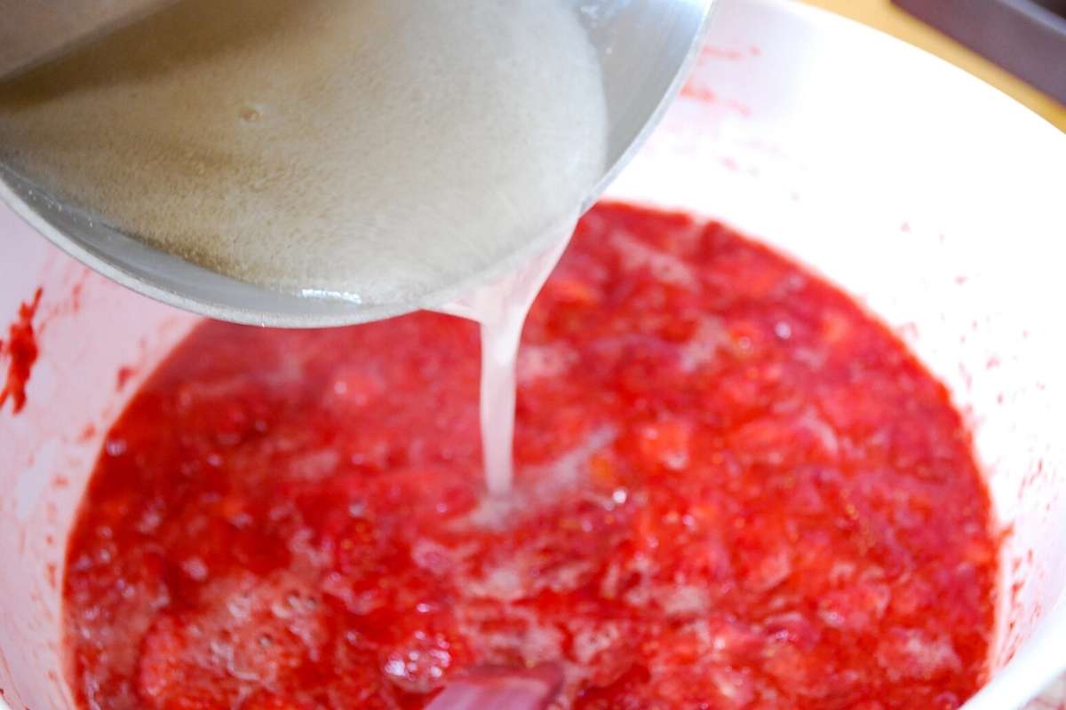 adding boiled pectin to crushed strawberries