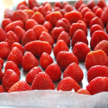 fresh strawberries on a baking sheet lined with wax paper