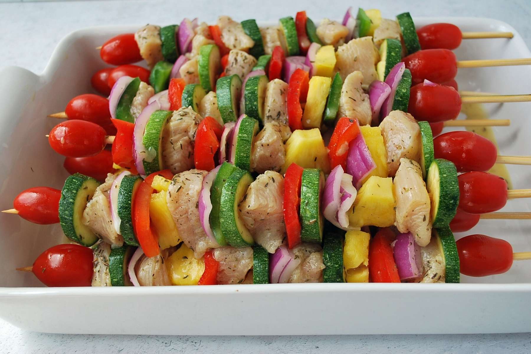 chicken kabobs in a baking dish ready to grill