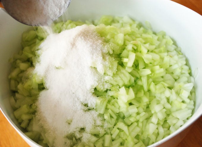 Chopped cucumbers in a bowl with salt on top