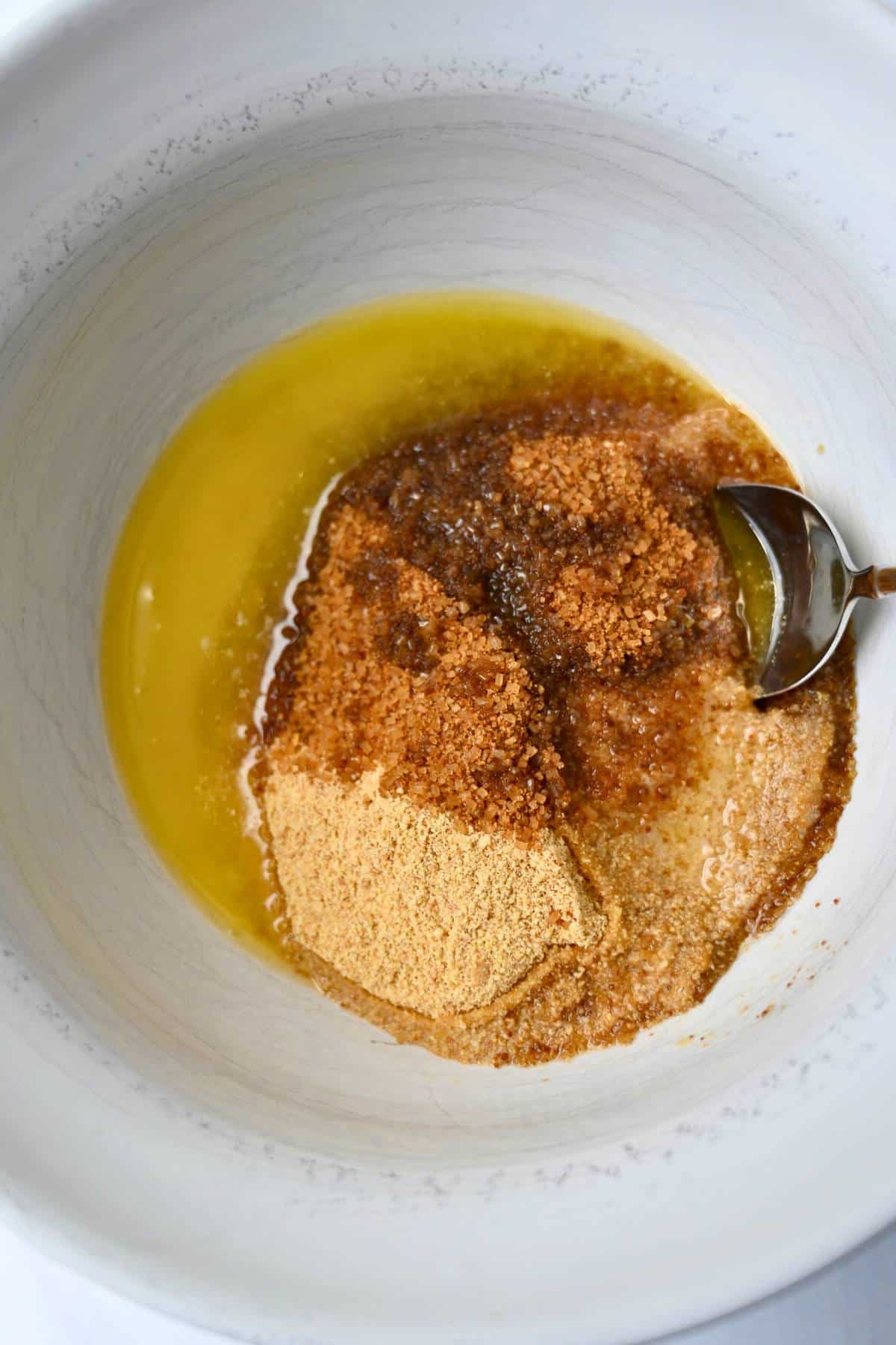 mixing ingredients for a graham cracker pie crust in a bowl