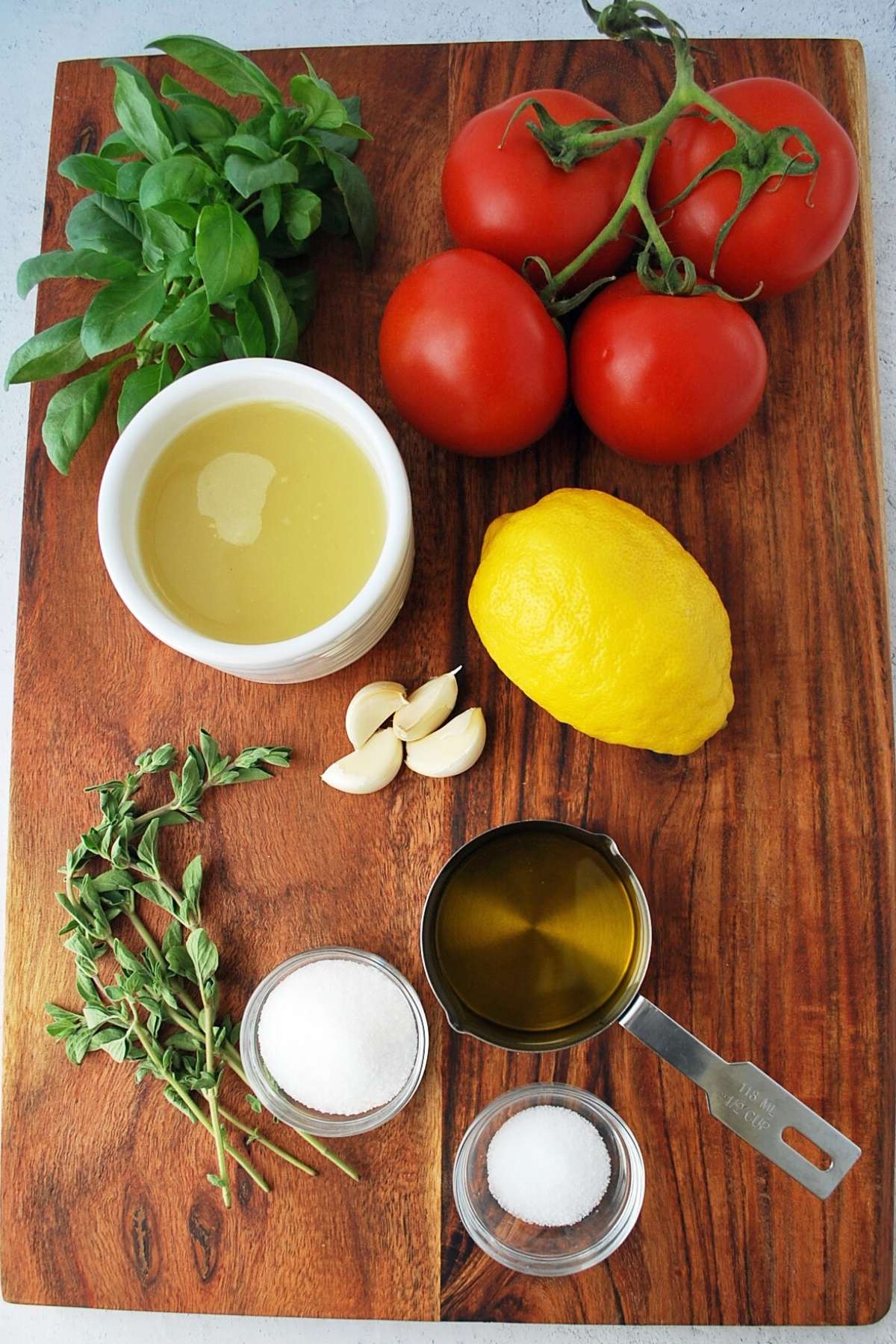 ingredients for tomato basil pasta sauce on a cutting board