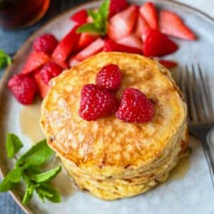 a stack of cottage cheese pancakes with raspberries on top