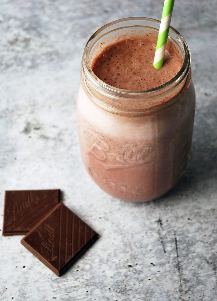 overhead photo of shake in a glass with chocolate squares in the background