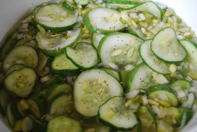 Sliced cucumbers covered in brine in a large bowl
