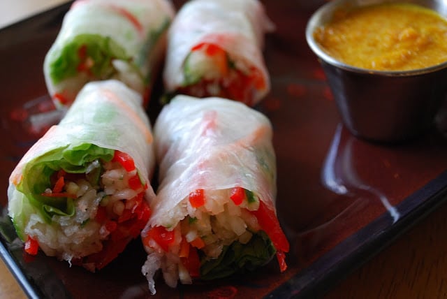 Close up photo of sliced Vietnamese salad rolls with a dipping sauce on the side