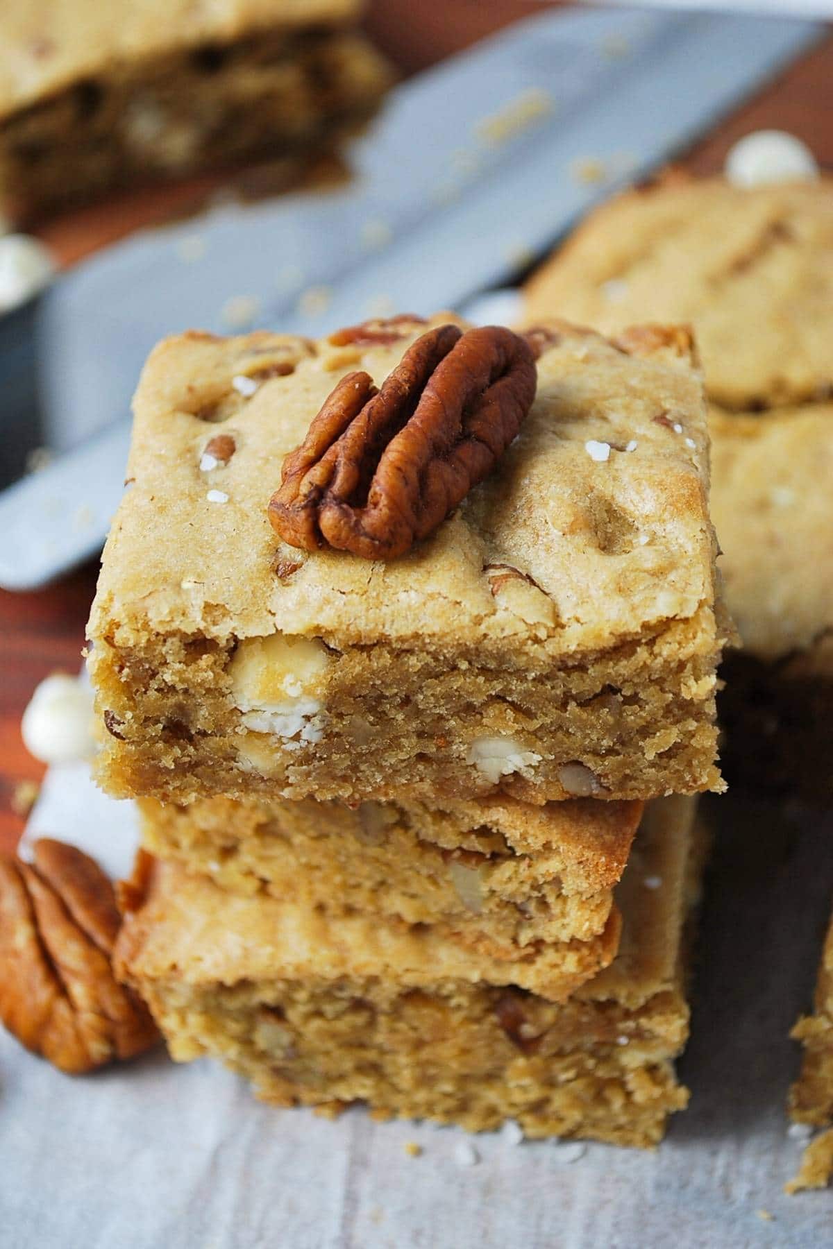 stack of gluten free blondies topped with a pecan 