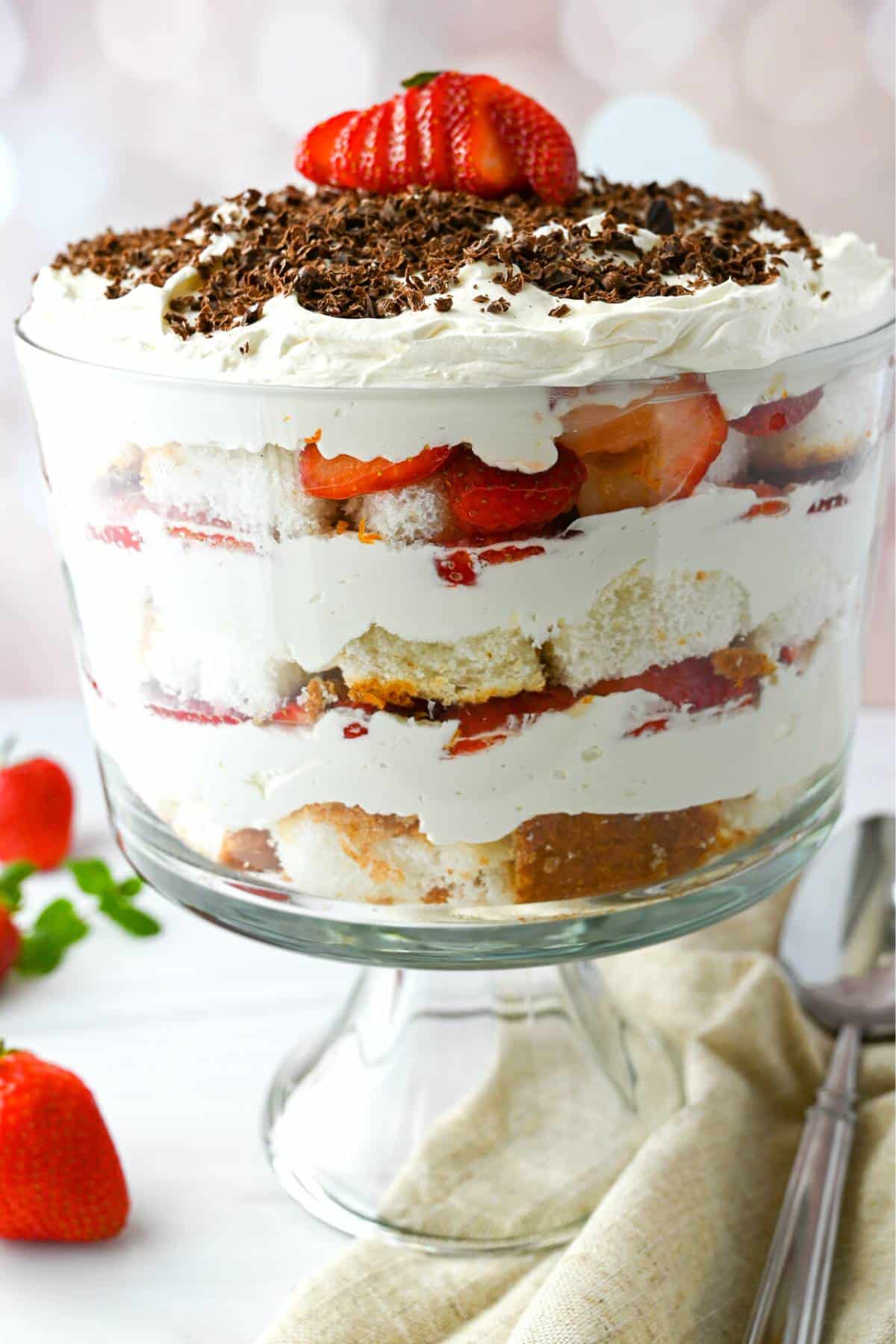 side view of a strawberry cheesecake trifle with a fanned strawberry on top