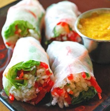 close up photo of two Vietnamese salad rolls on a plate with dipping sauce on the side