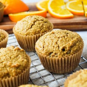 close up of a flaxseed muffin with orange slices behind it