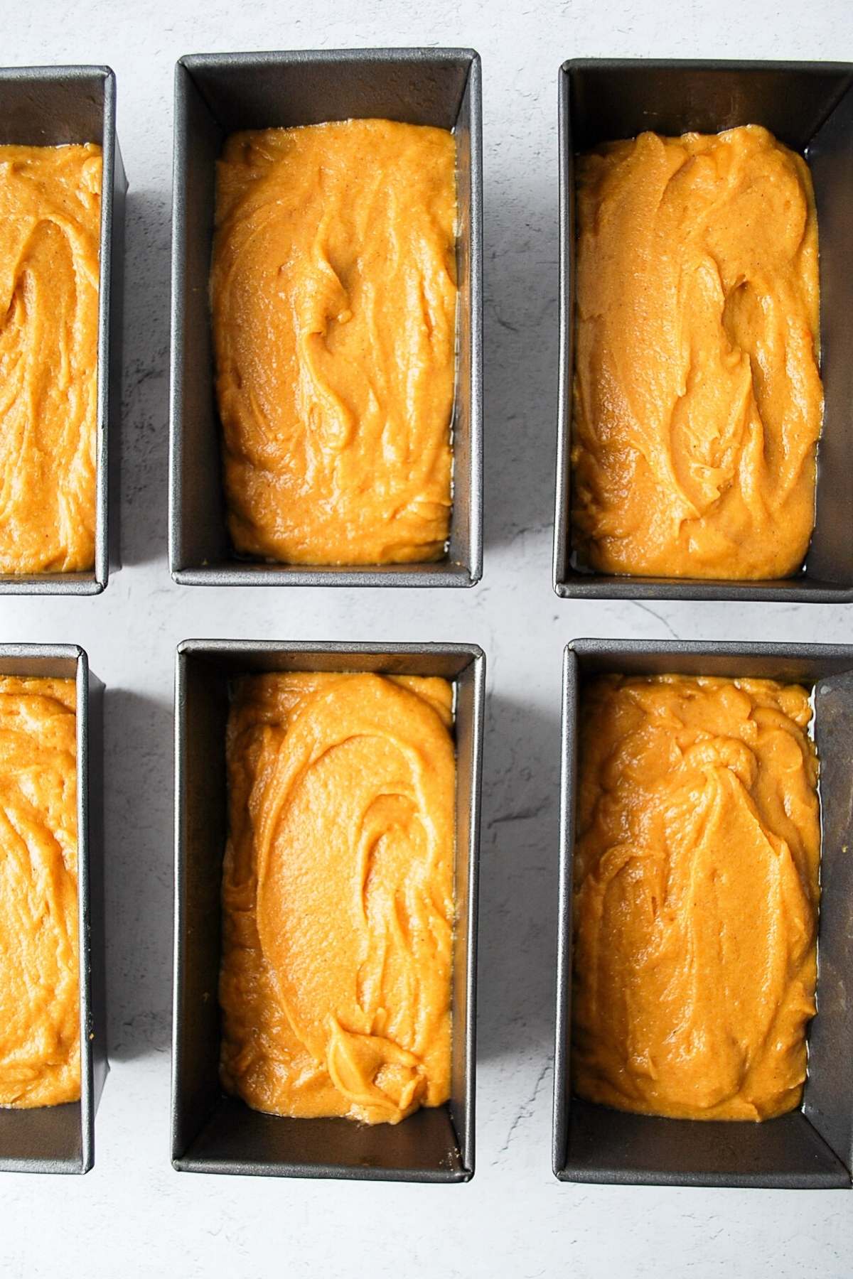 gluten-free pumpkin bread batter in mini loaf pans ready to bake