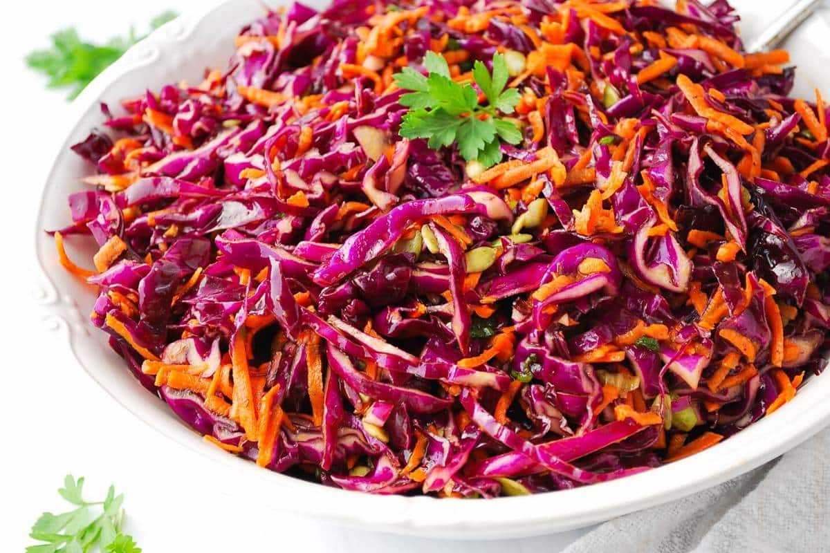 side view of a bowl of purple coleslaw with parsley around it