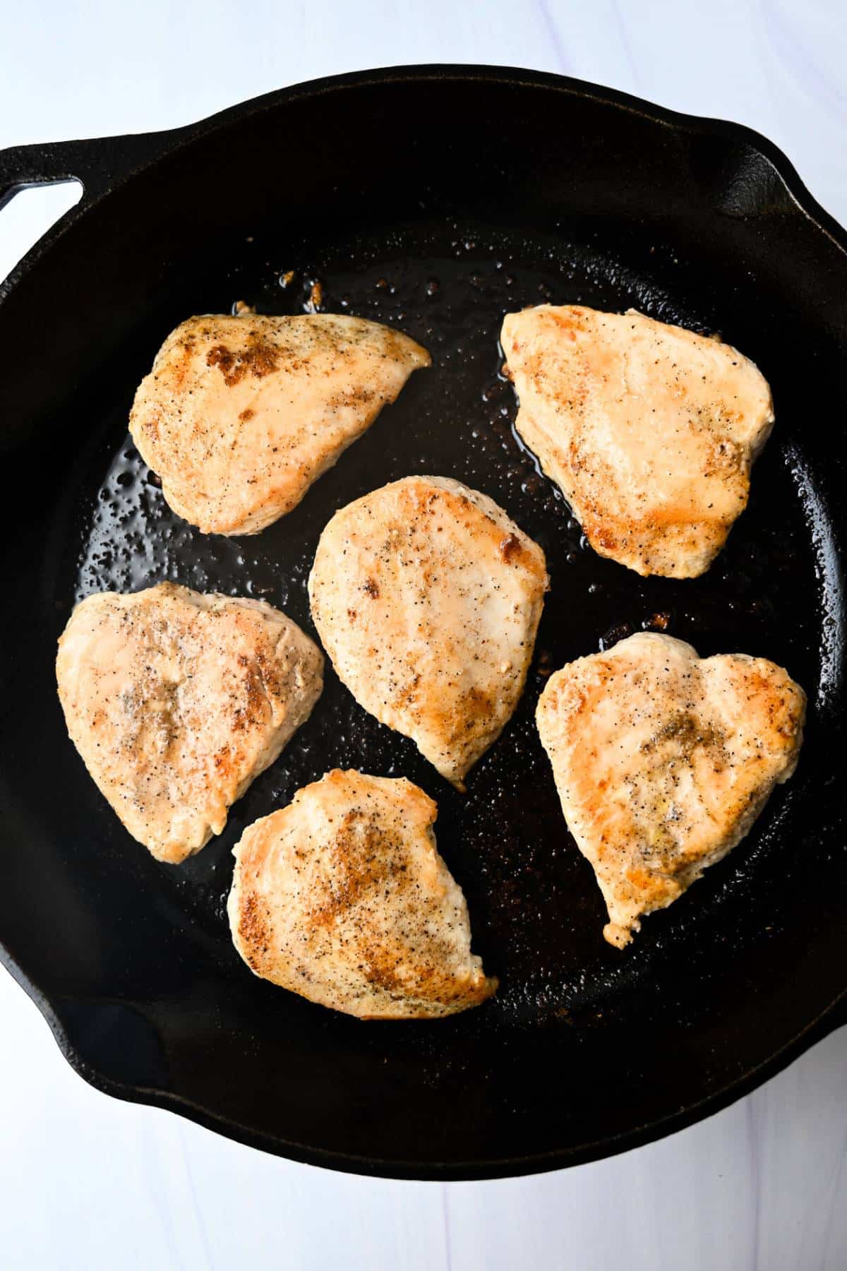 chicken breast seared in a cast iron skillet