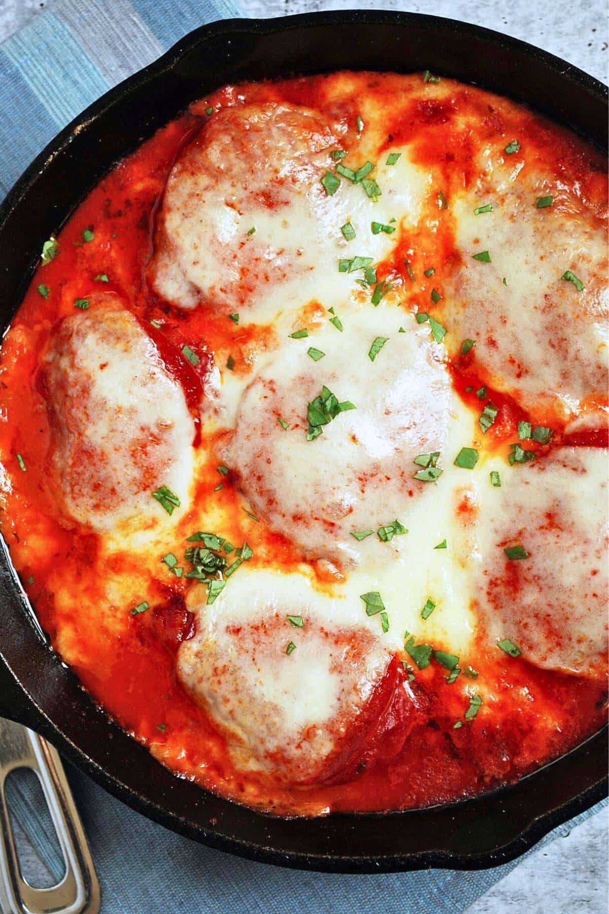 looking down at a pan of chicken breasts with marinara, pepperoni, and cheese