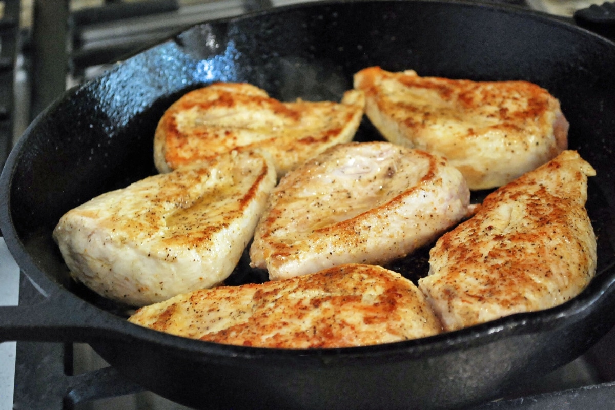chicken breasts seared in a cast iron skillet