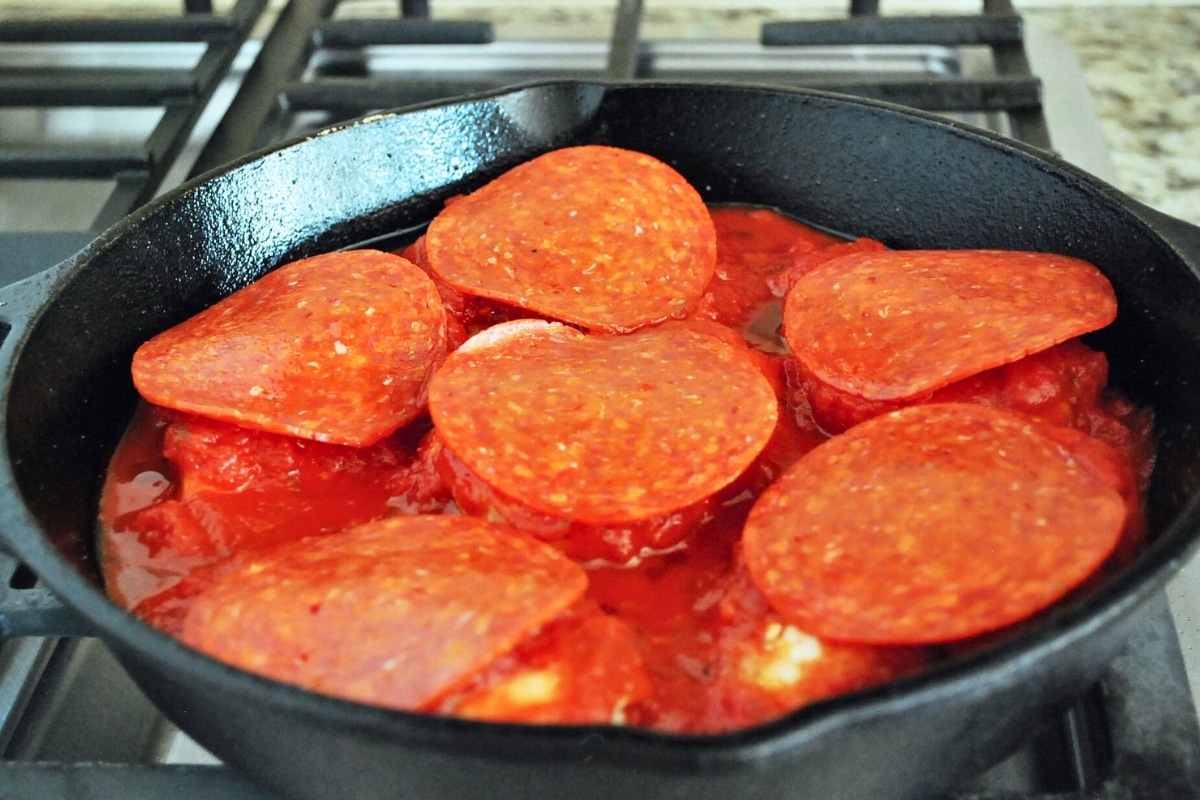chicken breasts topped with deli pepperoni and marinara in a skillet