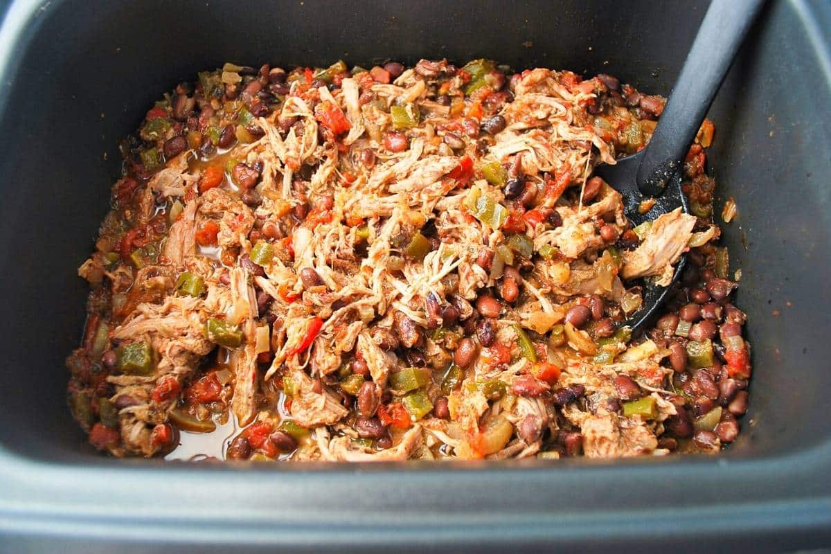 cooked pork tenderloin chili ready to serve in a slow cooker