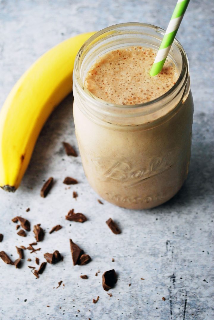 protein shake with banana and chocolate shavings with green straw