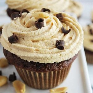 close up of a peanut butter frosting swirled on a cupcake with shaved chocolate on top