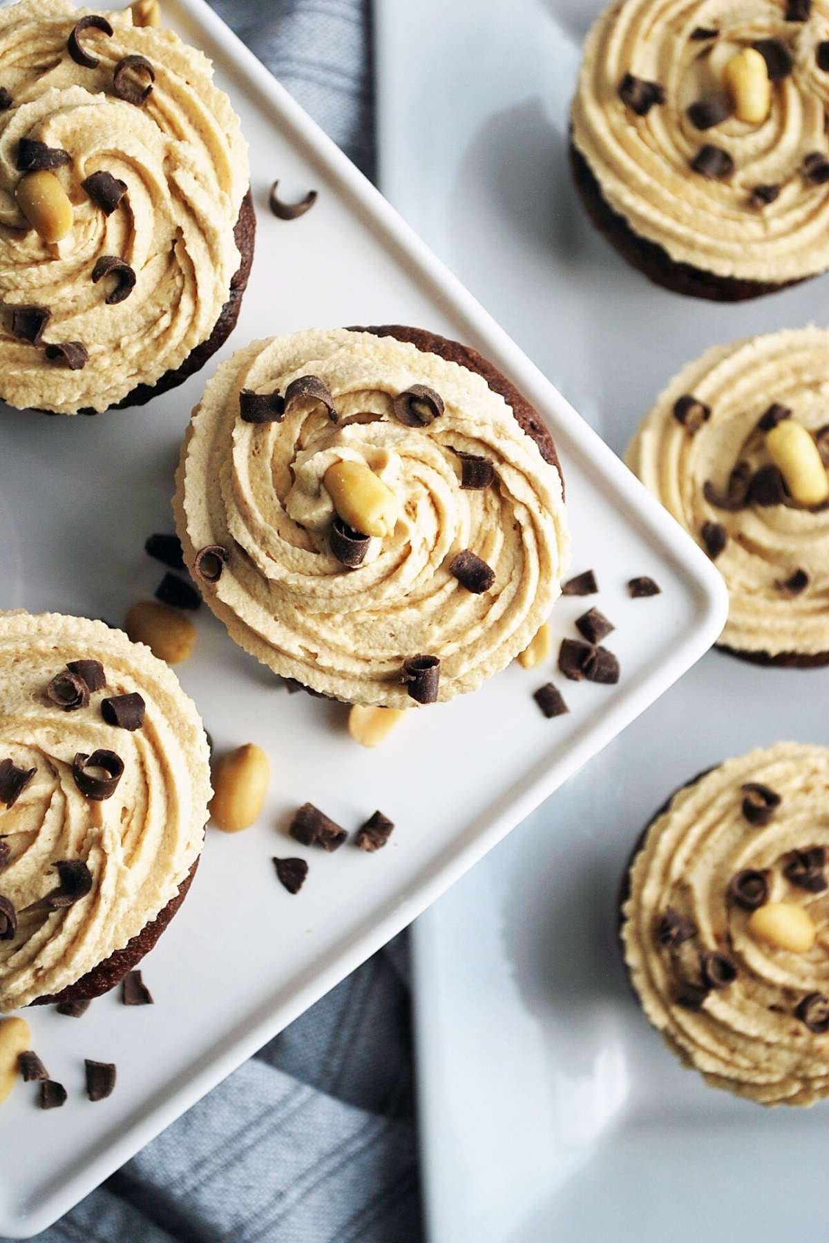 overhead photo looking down on a platter of frosted cupcakes topped with chocolate shavings