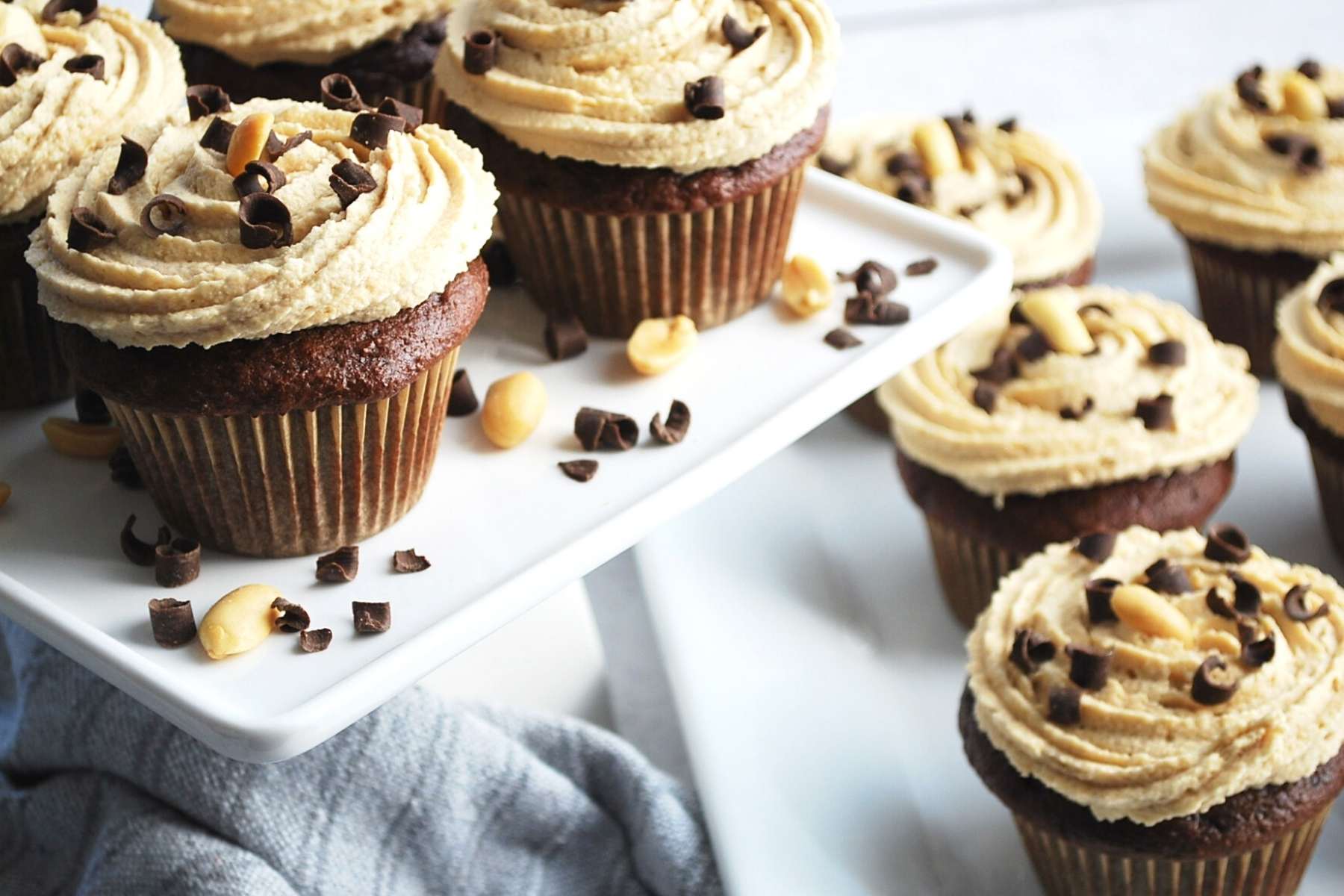 side view of a chocolate cupcakes with peanut butter cream cheese frosting swirled on top