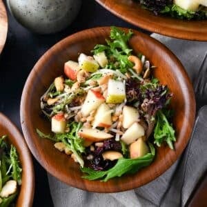 looking down at a bowl of farro salad with greens and fall fruits