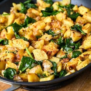 close up of potato spinach saute in a skillet