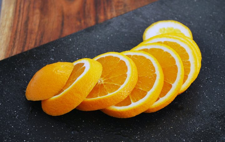 orange sliced on a black cutting board